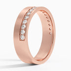 Angled view of rose gold men's wedding band with an off-center pave-set diamond stripe.