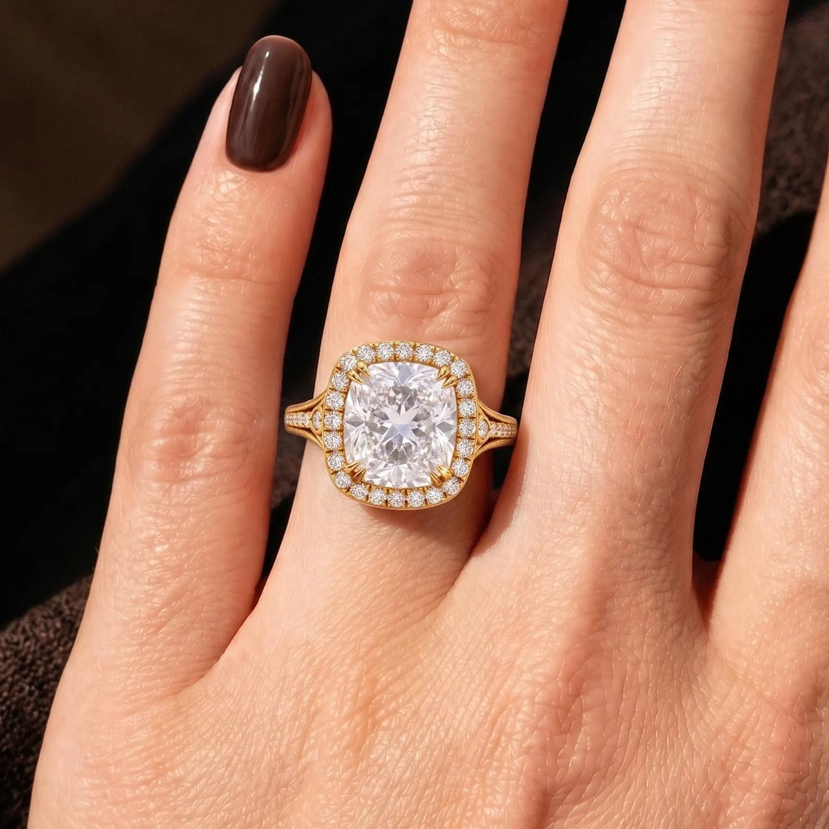 On-hand view of a large 4 carat cushion cut lab diamond halo ring in 14k yellow gold.