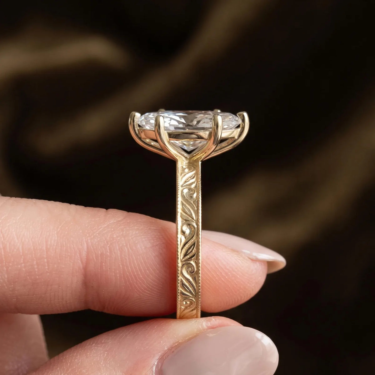 Side profile view of a 3 CT marquise cut lab grown diamond ring displaying hand-engraved scrollwork and milgrain band.