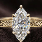 Ultra macro detail image of 3 CT marquise cut diamond facets and hand-carved floral pattern band with milgrain trim.