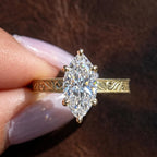 Top angle view showing the brilliance of a 3 carat marquise cut lab diamond set in 6 prongs on an engraved band.