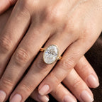 Elegant 4 carat oval lab diamond bezel engagement ring shown on crossed hands.