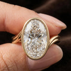 Extreme close up of 4 CT oval cut lab grown diamond in yellow gold bezel setting.