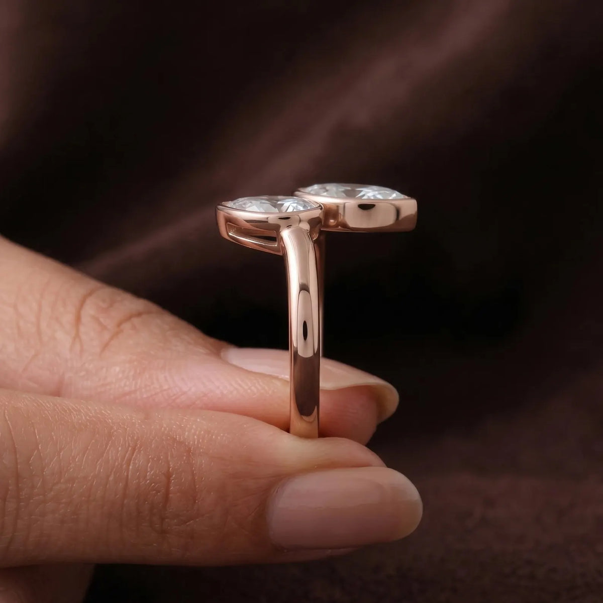 Side profile of rose gold Toi et Moi lab diamond open bezel setting and band.