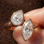 Extreme macro close up showing brilliance of pear and marquise cut lab diamonds in bezel settings.