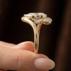 Side view profile of 3 carat pear lab grown diamond bezel ring in yellow gold held by hand.