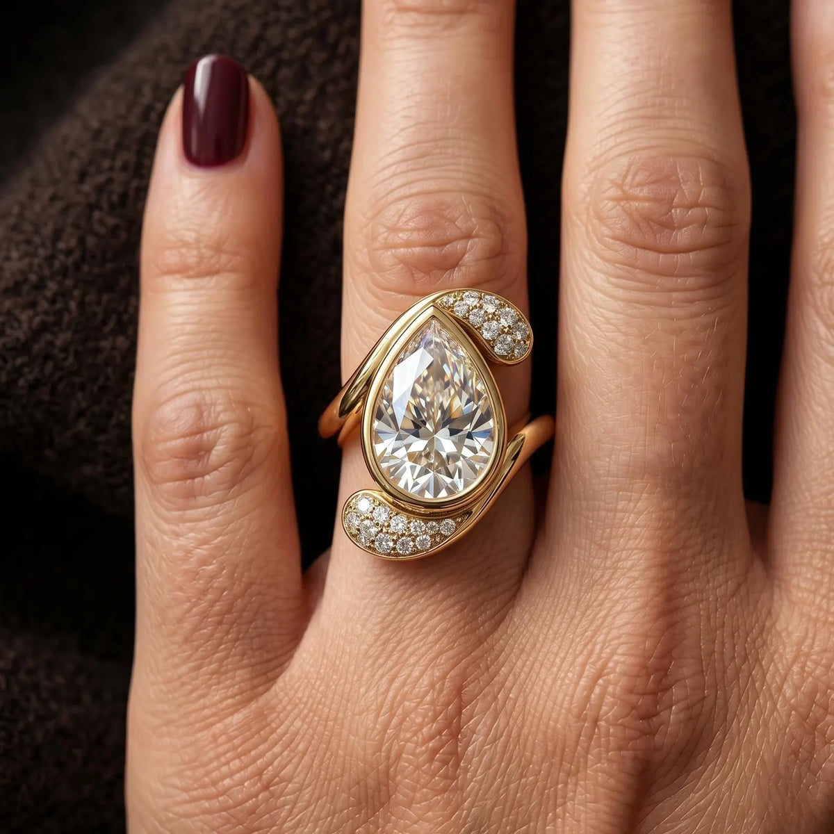 Top view of 3 carat pear cut lab grown diamond ring with pavé swirl setting on finger.