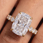 Close up view of 4 CT elongated cushion cut lab grown diamond ring with claw prongs in gold.