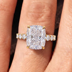 Top view of 4 carat elongated cushion lab diamond ring with accent band on finger.