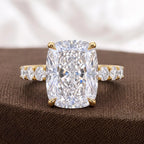 Front view of 4 CT elongated cushion cut diamond ring sitting on textured brown fabric.