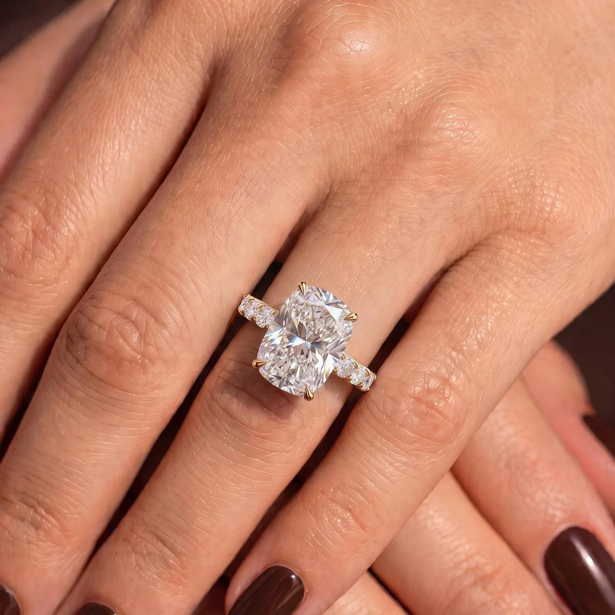 Crossed hands showcasing a 4 carat elongated cushion lab grown diamond engagement ring.