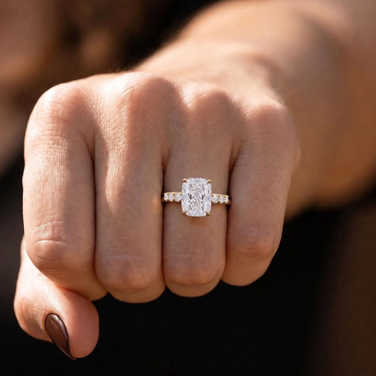 Front facing hand shot featuring 4 CT elongated cushion lab diamond ring in natural sunlight.
