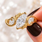 Macro close-up of a 2 carat marquise cut lab grown diamond engagement ring with botanical leaf carvings in 14K yellow gold.