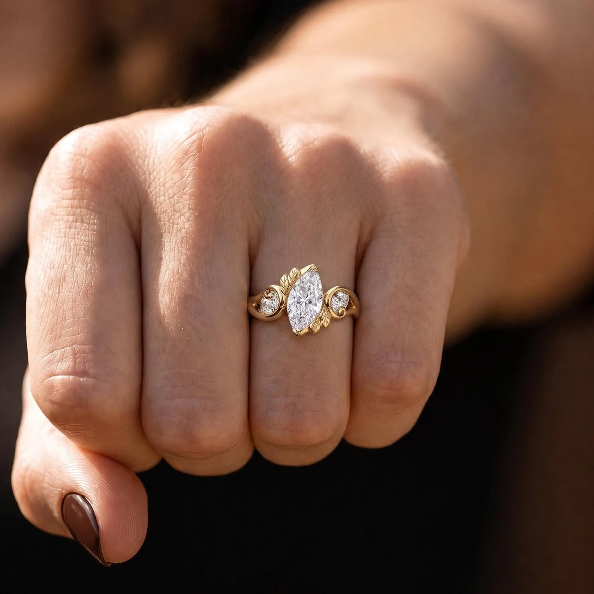 Full hand perspective showing the rich yellow gold and unique floral leaf setting of a 2 carat marquise lab diamond ring.