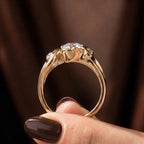 Side profile angle showing the open-work cathedral gallery and leaf scroll structure of the yellow gold ring.