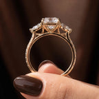 Side profile view showing the open cathedral setting and pavé bridge of a 3 carat radiant cut diamond ring.
