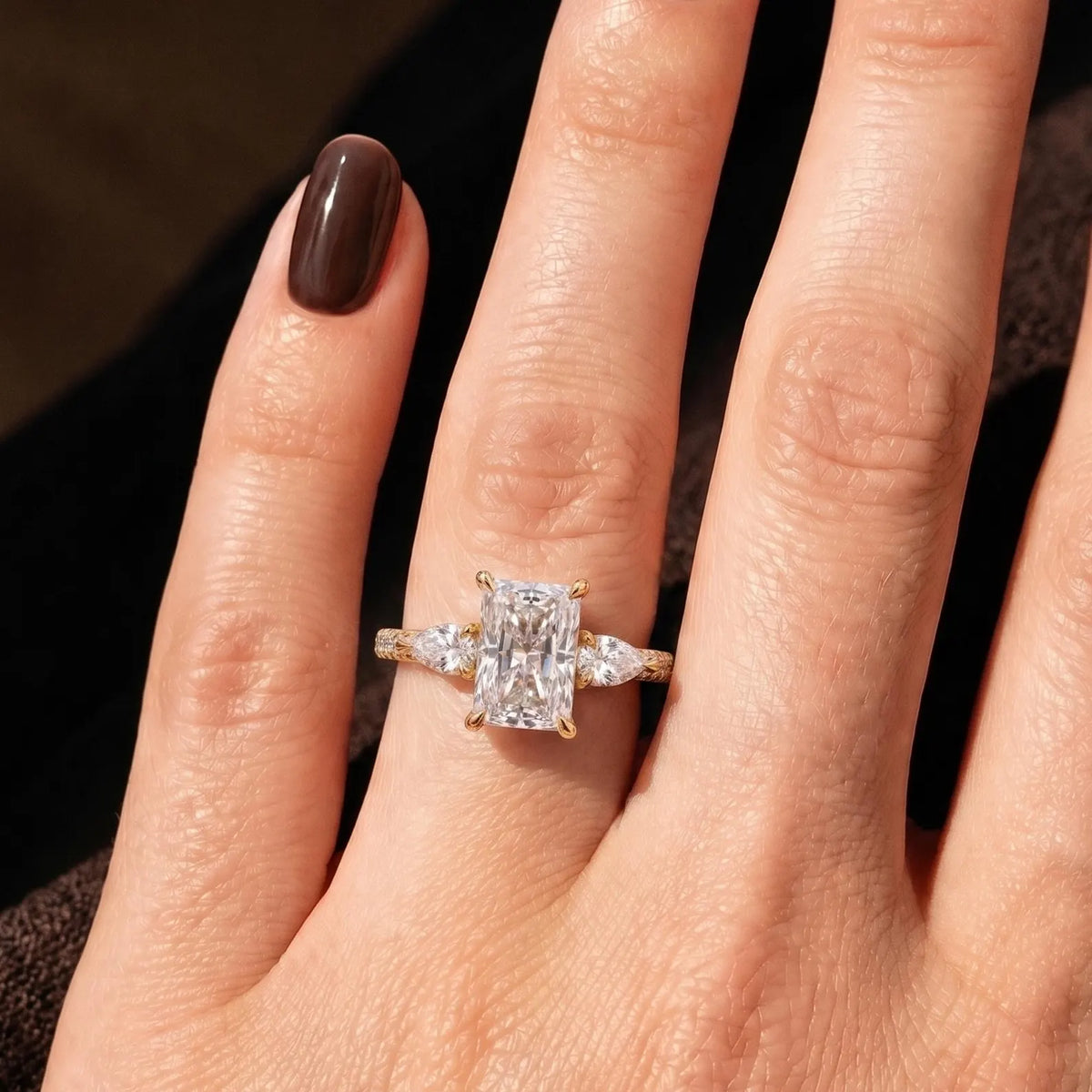 Direct on-hand perspective showcasing the sparkle of a 3 CT radiant lab diamond ring in warm light.