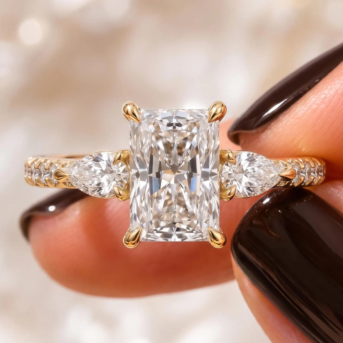 Detailed close-up view highlighting the radiant facets, claw prongs, and pear side diamonds in gold.