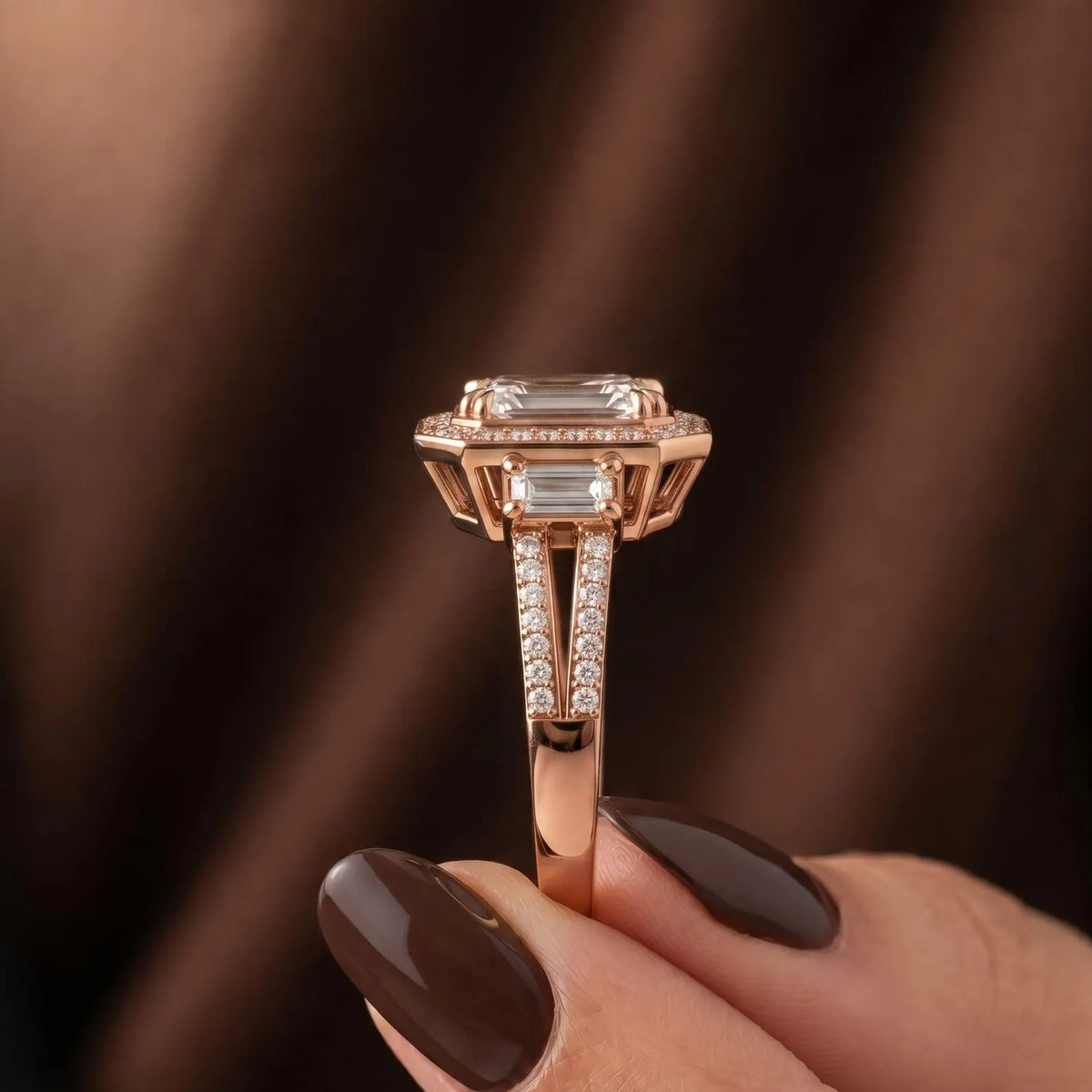 Side profile view of a 3 CT emerald cut lab grown diamond ring in rose gold showcasing the detailed basket gallery and pave band.