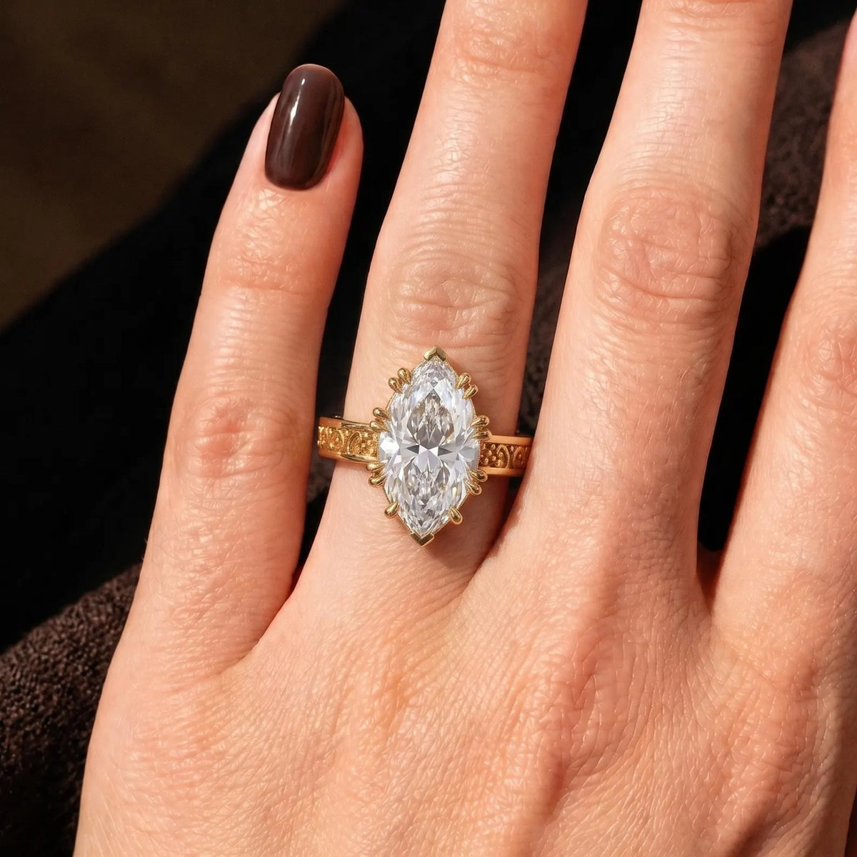 Direct top view of a 3 CT marquise cut lab grown diamond ring featuring ornate scrollwork on the gold shank.