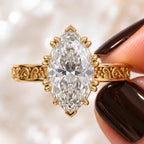 Macro close-up of a 3 CT marquise cut diamond ring highlighting the starburst multi-prong setting and filigree details.