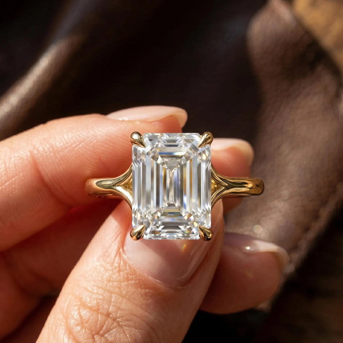 Macro view of a 4 CT emerald cut lab diamond showing step-cut facet clarity and yellow gold setting.