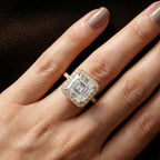 On-hand close-up view of a 3 CT Asscher cut lab-grown diamond halo engagement ring in 14K yellow gold.