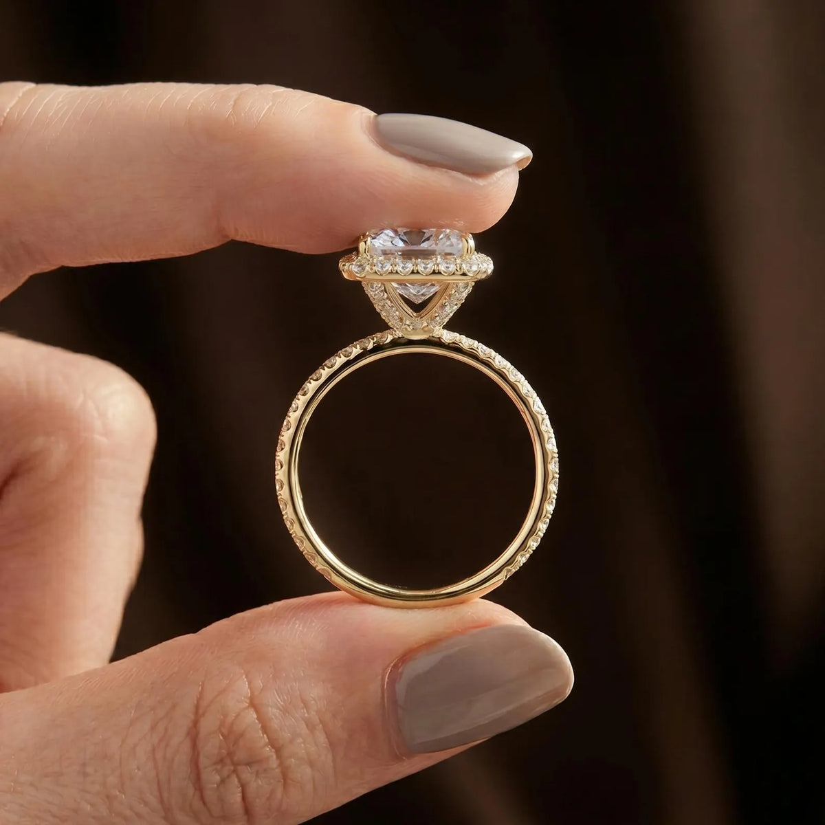 Side profile view of Asscher lab diamond engagement ring held between fingers highlighting pave basket gallery and thin pave shank.