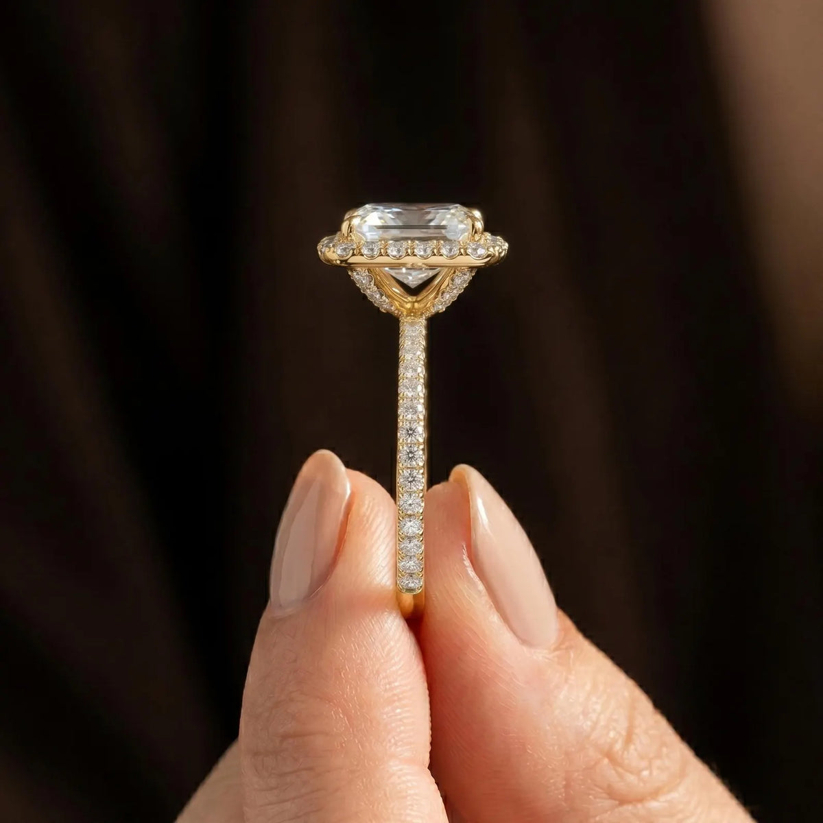 Edge side-shot of 14k yellow gold Asscher cut halo ring displaying thin diamond pave band structure.