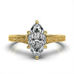 Overhead top view of a 3 carat marquise cut lab grown diamond solitaire ring in yellow gold with an engraved band.