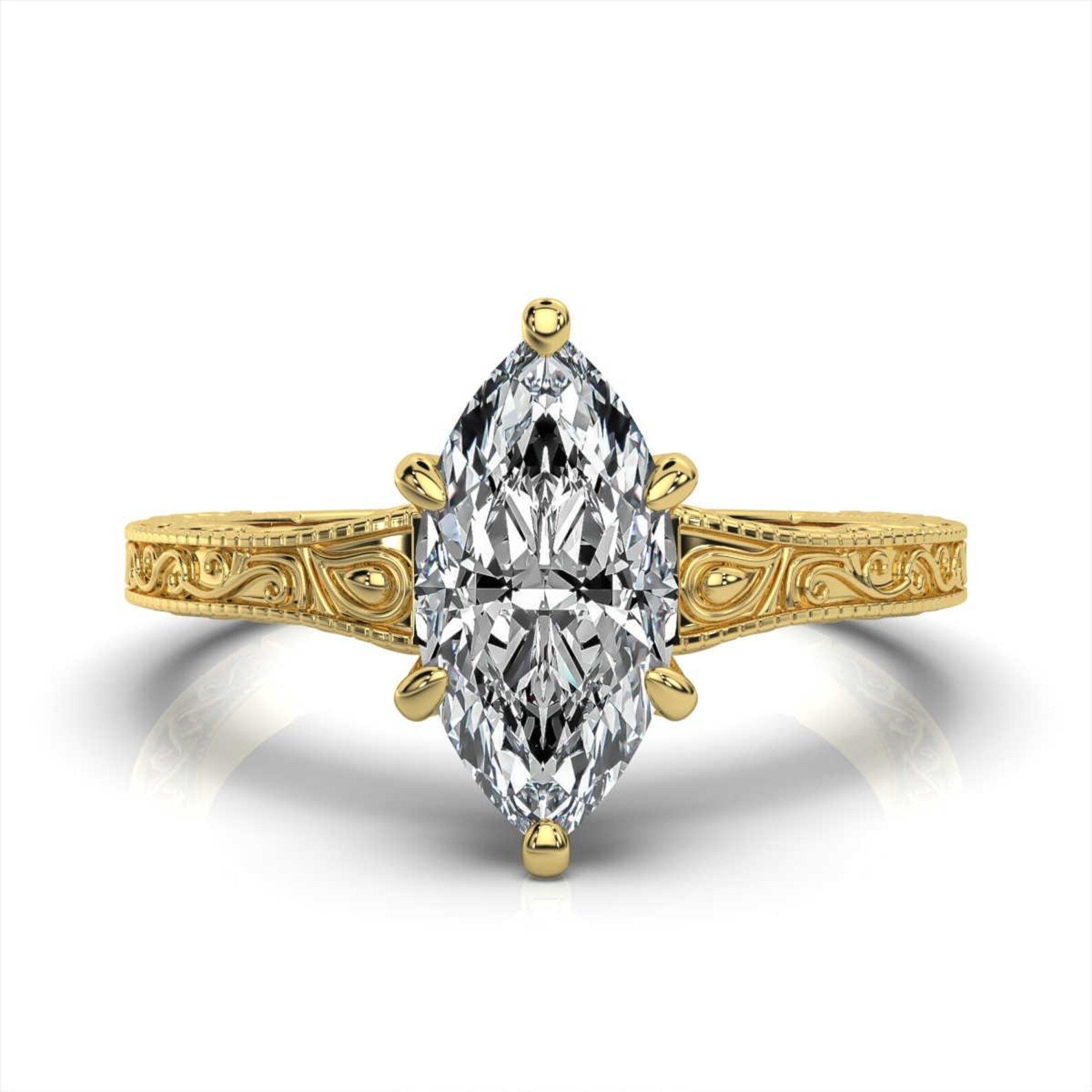 Overhead top view of a 3 carat marquise cut lab grown diamond solitaire ring in yellow gold with an engraved band.