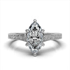 Top-down view of a 3ct marquise cut lab diamond engagement ring in white gold with vintage filigree details.