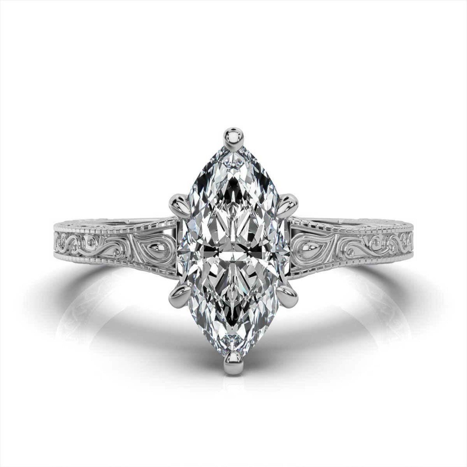 Top-down view of a 3ct marquise cut lab diamond engagement ring in white gold with vintage filigree details.