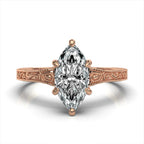 Top view of a rose gold hand-engraved scrollwork engagement ring with a 3 carat marquise lab-grown diamond.