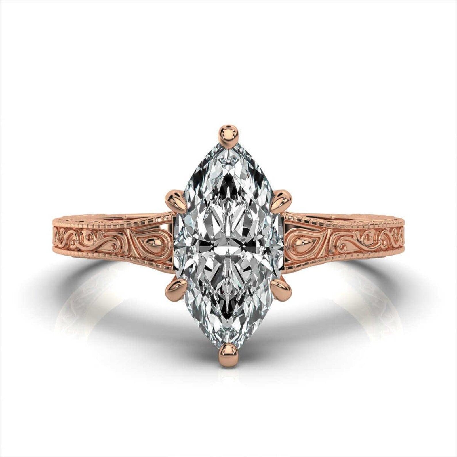 Top view of a rose gold hand-engraved scrollwork engagement ring with a 3 carat marquise lab-grown diamond.