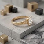 Side profile angle of a 2 CT oval lab-created diamond ring highlighting hand-carved leaf filigree and milgrain edge.