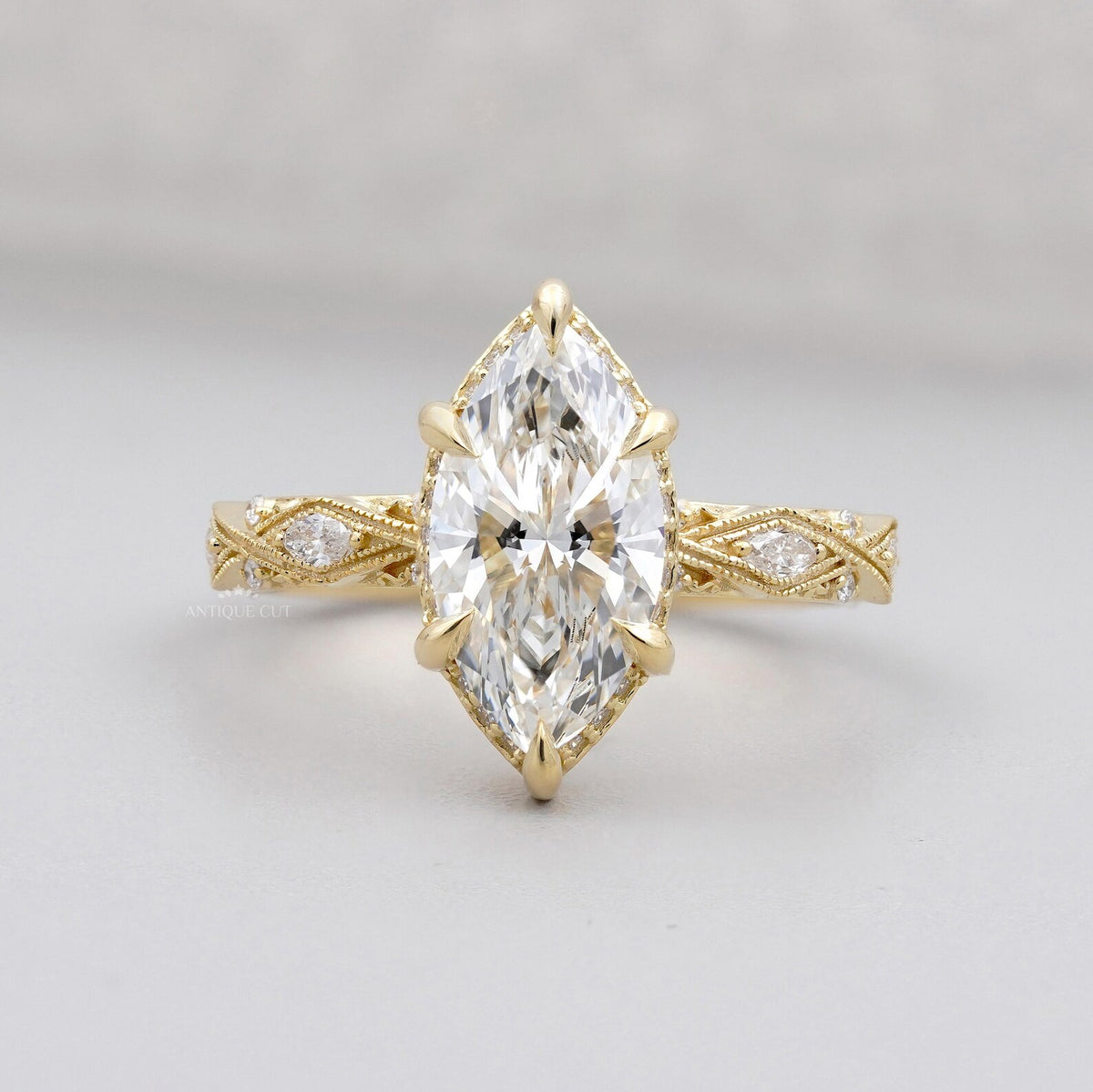 Top view of a 3 carat marquise cut lab grown diamond engagement ring in 14K yellow gold featuring a vintage lattice band and 6-prong head.