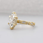 Side profile view of a 3 carat marquise lab diamond ring highlighting the textured milgrain lattice band and diamond-encrusted basket.