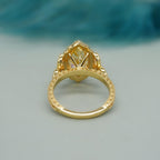 Bottom profile view showing the intricate lattice engraving and gallery setting of a yellow marquise lab diamond ring.