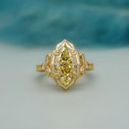 Top-down view of a 4 CT fancy yellow marquise cut lab grown diamond in a scalloped milgrain halo setting.