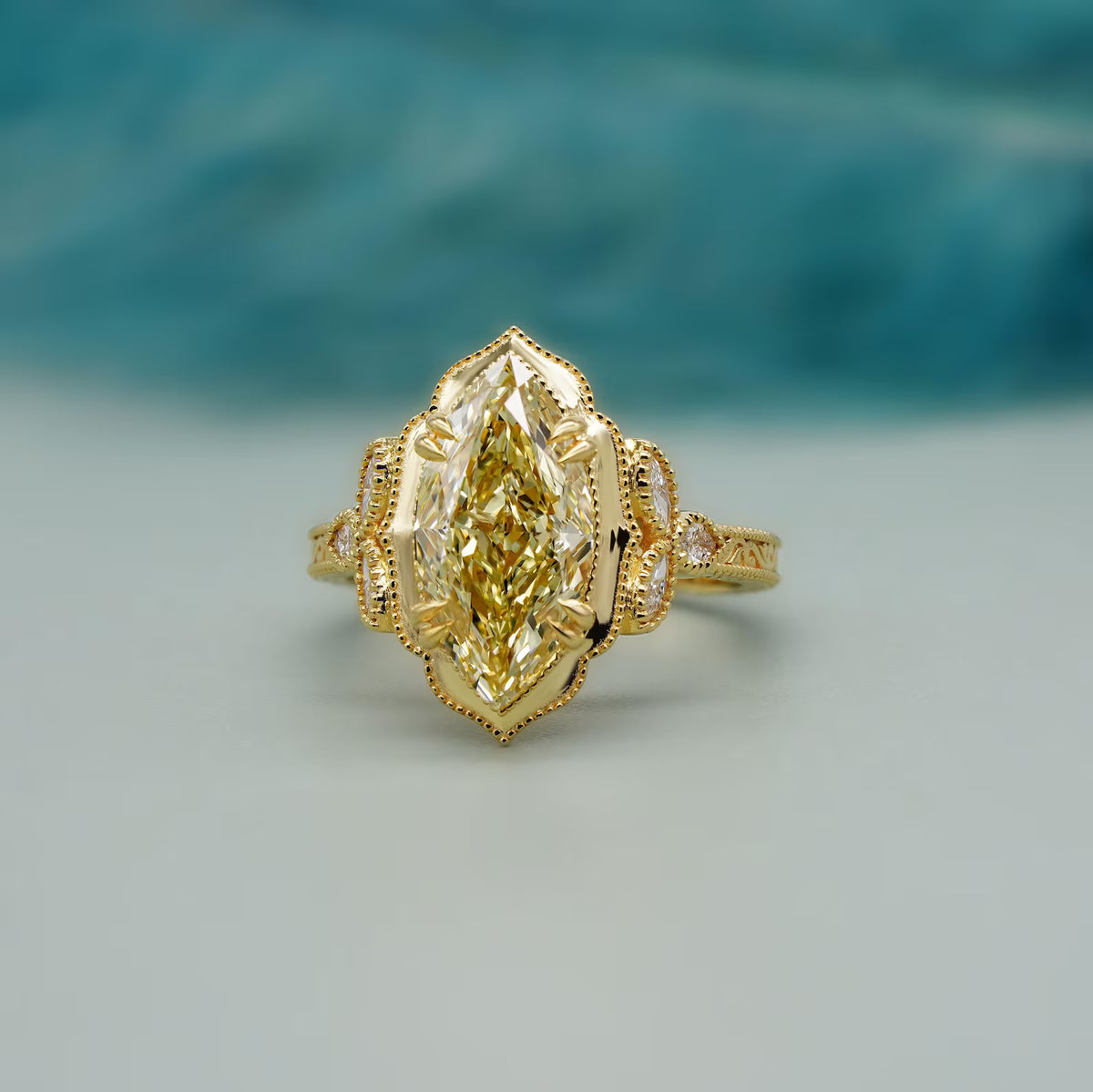 Frontal studio shot of a 4 CT yellow marquise cut lab diamond ring with milgrain halo and side accent stones.