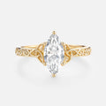 Top-down front view of a 2ct marquise lab created diamond set in a 14k yellow gold Trinity knot band.
