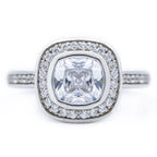 Top view of a 2 CT cushion cut lab grown diamond engagement ring with a bezel halo setting in 14k white gold.