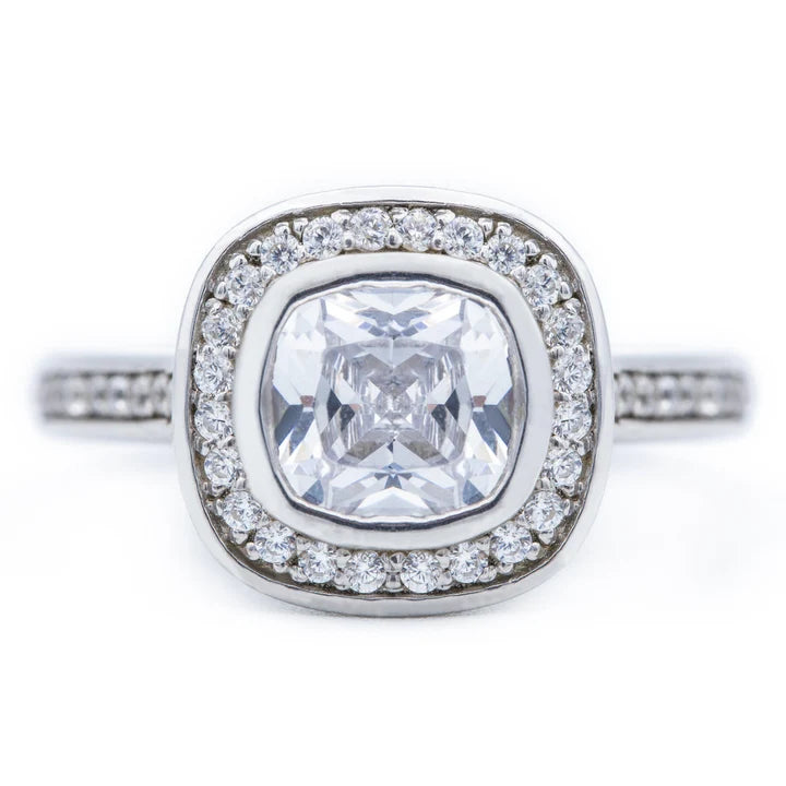 Top view of a 2 CT cushion cut lab grown diamond engagement ring with a bezel halo setting in 14k white gold.