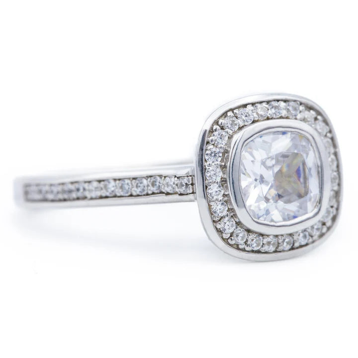 Angled view of a 2 carat cushion lab diamond ring featuring a micro pave halo and diamond-accented band.