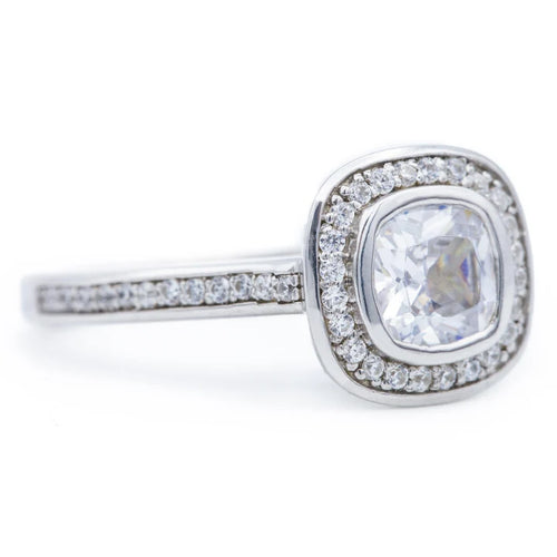 Angled view of a 2 carat cushion lab diamond ring featuring a micro pave halo and diamond-accented band.