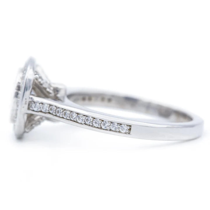Side profile showing the cathedral pave shank and elevated bezel halo head of a white gold cushion diamond ring.