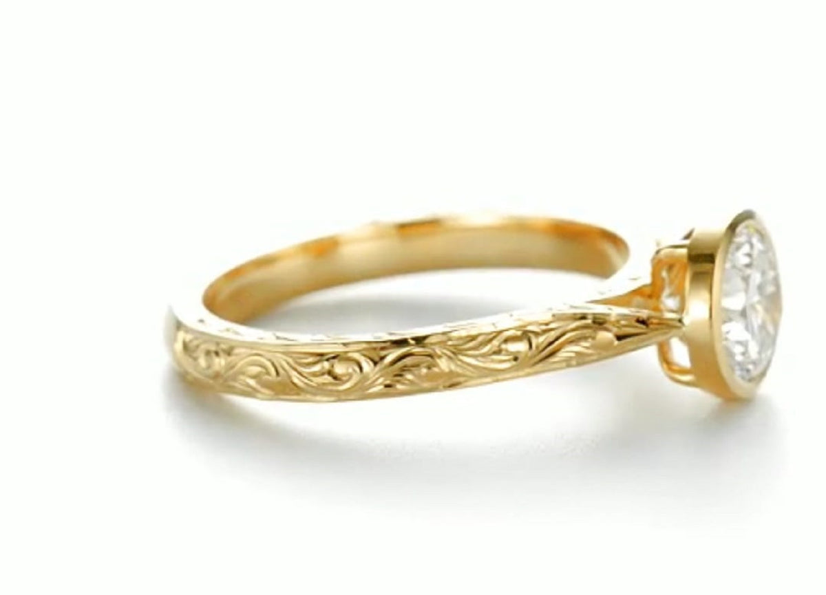 Side profile of yellow gold ring highlighting intricate floral scrollwork engraving.