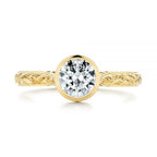 Direct top view of 2 CT round cut sparkling lab created diamond in a protective gold bezel frame.