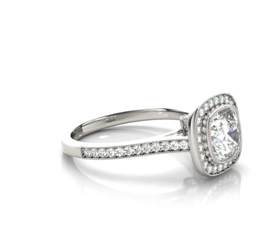 Angled view showcasing the cushion cut lab diamond center stone and milgrain-bordered pavé diamond band.